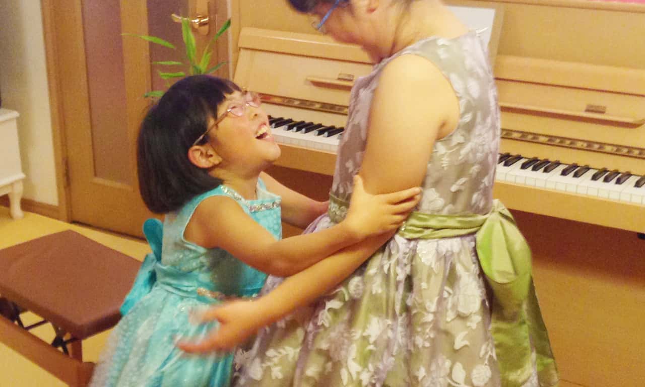 写真:ピアノ発表会の衣装で盛り上がる仲良しの二人