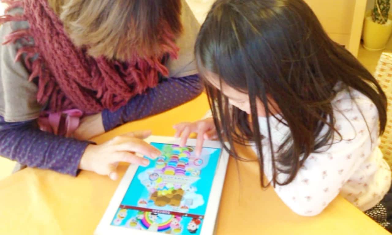 写真:お母さんと一緒にiPadのアプリを楽しむ女の子