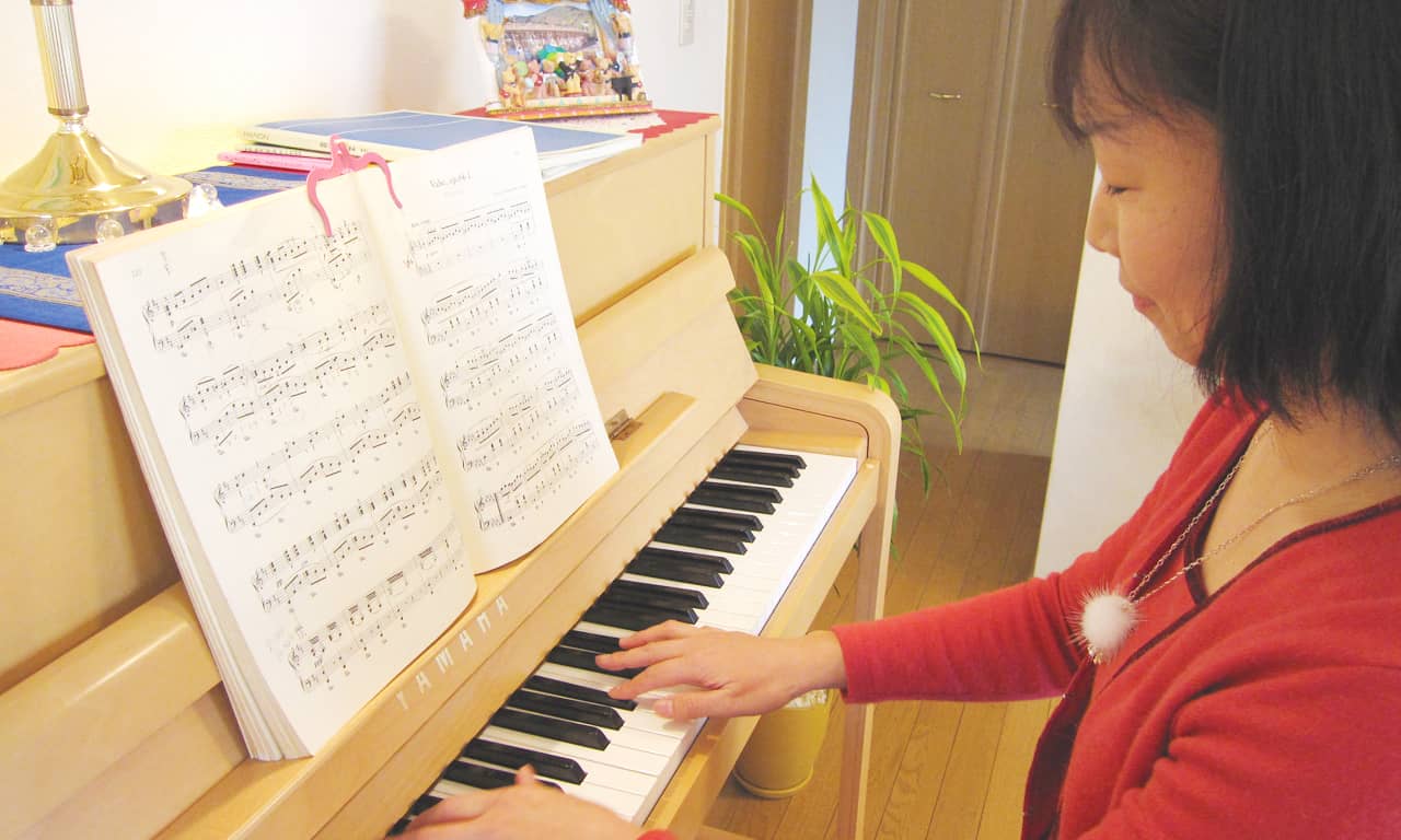 写真:楽しげにピアノを弾いているH.T様