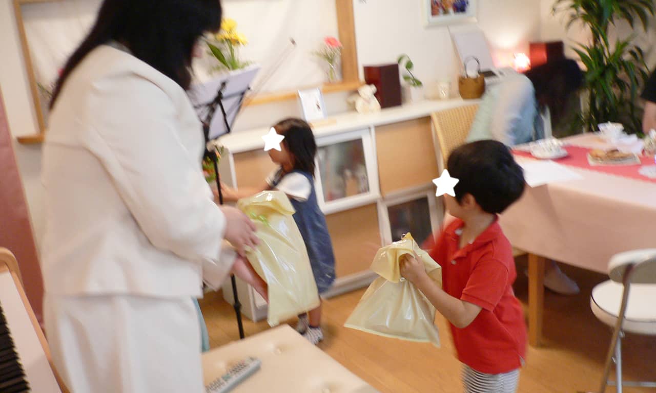 写真：進藤瑞希さんと福田りえにプレゼントを渡す小さな女の子と男の子
