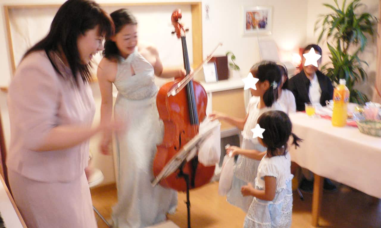 写真：演奏が終わった三澤亜美さんに、小さな生徒さん2人からプレゼントが贈られている様子