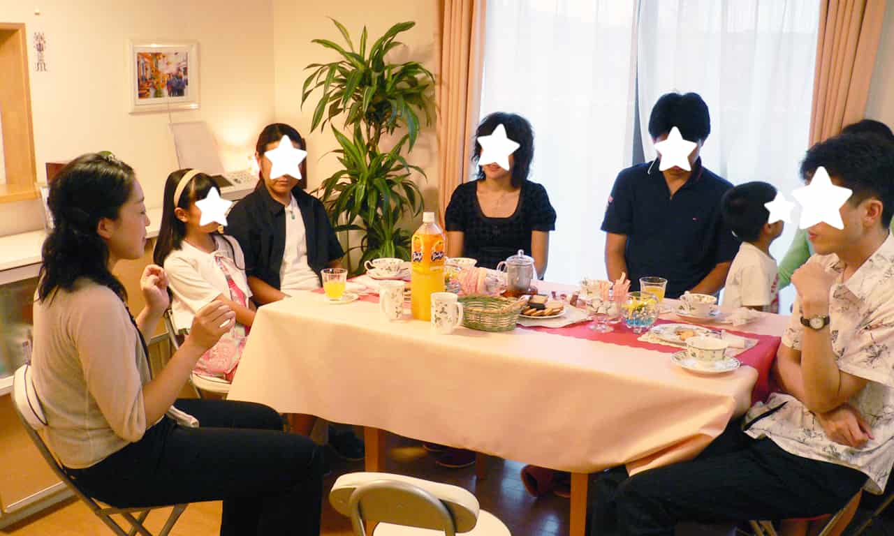 写真：コンサート後にテーブルで歓談している三澤亜美さんと生徒さんたち