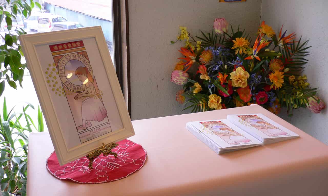 写真：受付のテーブルに置いてある発表会プログラムと、額に入っているA4サイズのポスター