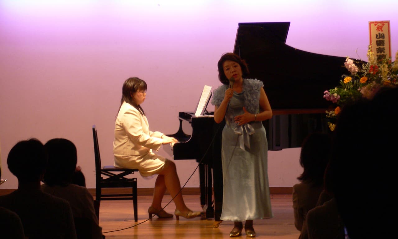 写真：講師のピアノ伴奏でオリジナルソング『天使の子守唄』を歌う、歌手の久松愛さん