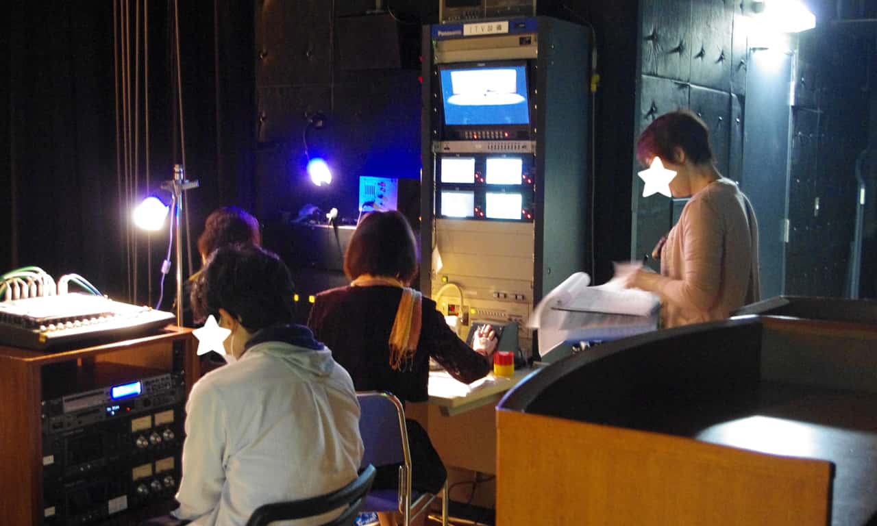 写真：モニターや音響機材の前で、本番の準備に余念がないスタッフのみなさんの様子