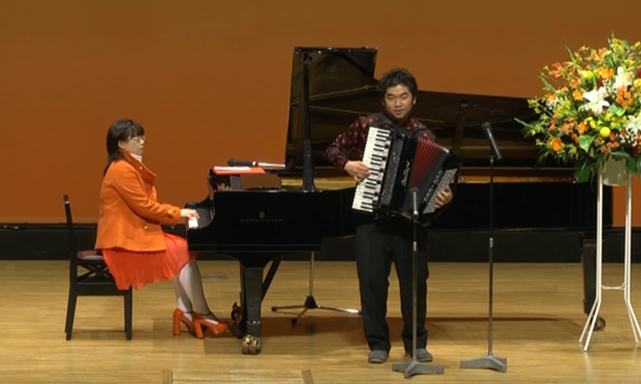 写真：講師のピアノ伴奏でアコーディオンを演奏するゲストの田ノ岡三郎さんのステージ