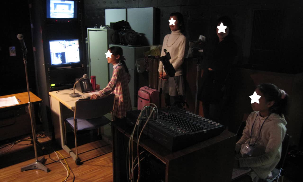 写真：舞台袖のモニターの前で本番を待つスタッフのみなさんの様子