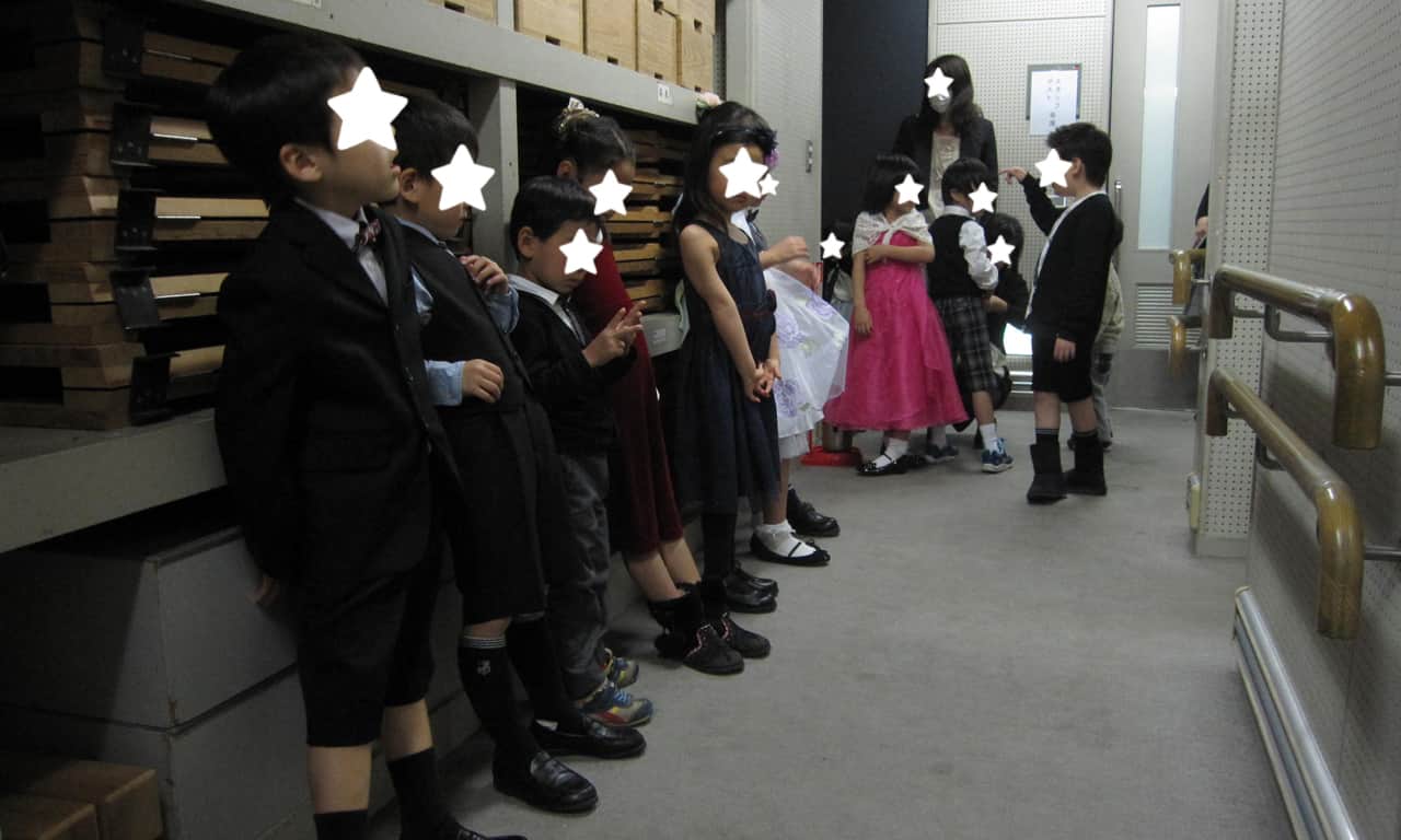 写真：ステージ裏の廊下に集合している小さな子どもたちの様子
