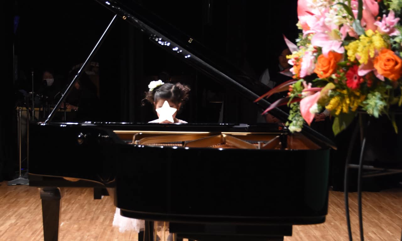 写真：綺麗な飾り花とピアノを弾く女の子