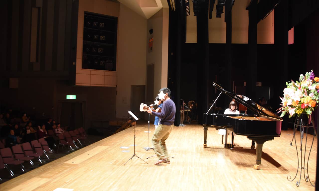 写真：お父さんのミニギターに合わせて歌う男の子